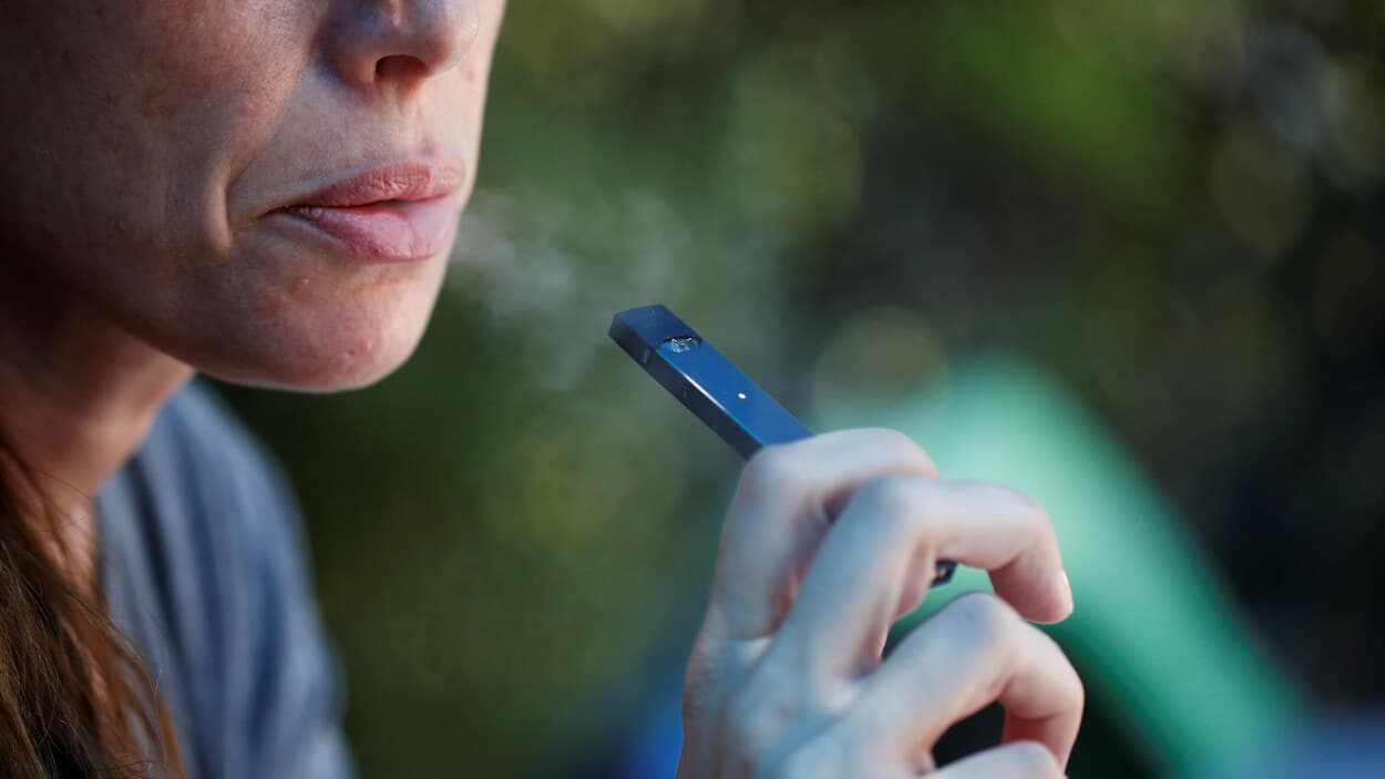 Femme utilisant une cigarette électronique dans un cadre détendu